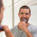 man brushing his teeth at home, oral-care routine