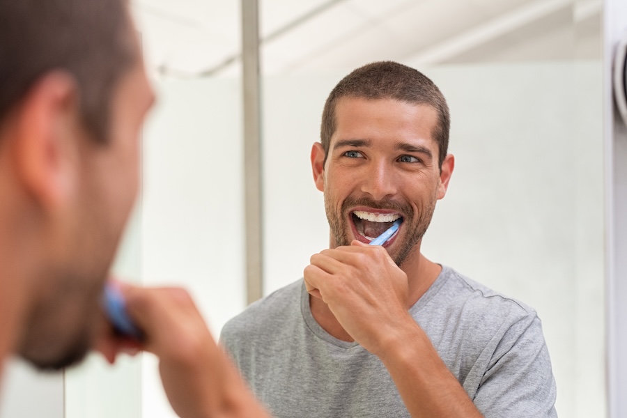 man brushing his teeth at home, oral-care routine